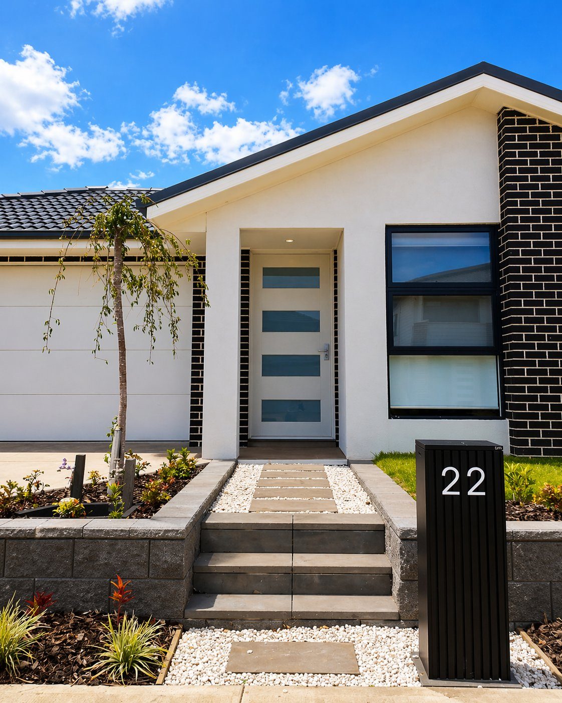 Modern home entry with pebble pathway